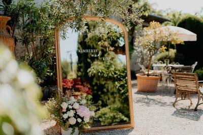 Un couple souriant marche main dans la main au milieu d'invités applaudissant lors d'une cérémonie en plein air.
