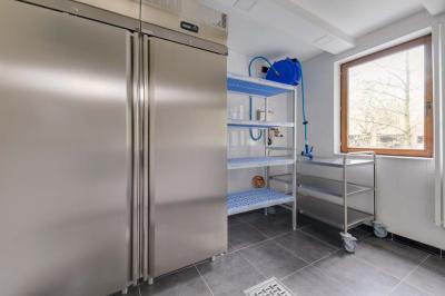 Des personnes discutent debout dans un espace extérieur, entourées de verdure et de mobilier de jardin.