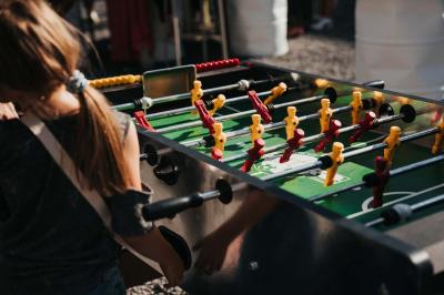 Des personnes discutent debout dans un espace extérieur, entourées de verdure et de mobilier de jardin.