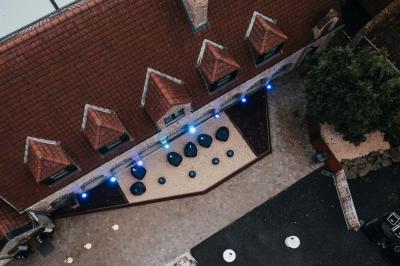 Des personnes discutent debout dans un espace extérieur, entourées de verdure et de mobilier de jardin.