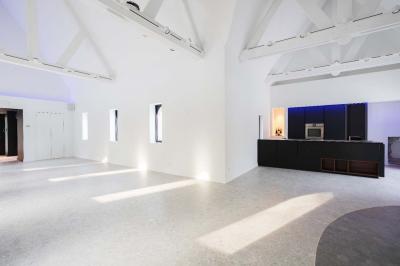 Des personnes discutent debout dans un espace extérieur, entourées de verdure et de mobilier de jardin.