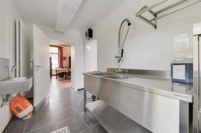 Des personnes discutent debout dans un espace extérieur, entourées de verdure et de mobilier de jardin.