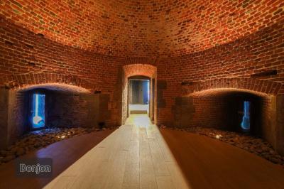 Des personnes discutent debout dans un espace extérieur, entourées de verdure et de mobilier de jardin.