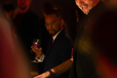 Une femme tourne une roue colorée de jeu avec des chiffres dans un environnement éclairé en rose.