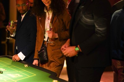 Une femme tourne une roue colorée de jeu avec des chiffres dans un environnement éclairé en rose.