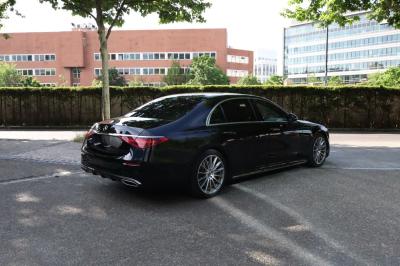 Vue intérieure d'une voiture haut de gamme avec tableau de bord moderne, écran central et toit panoramique.
