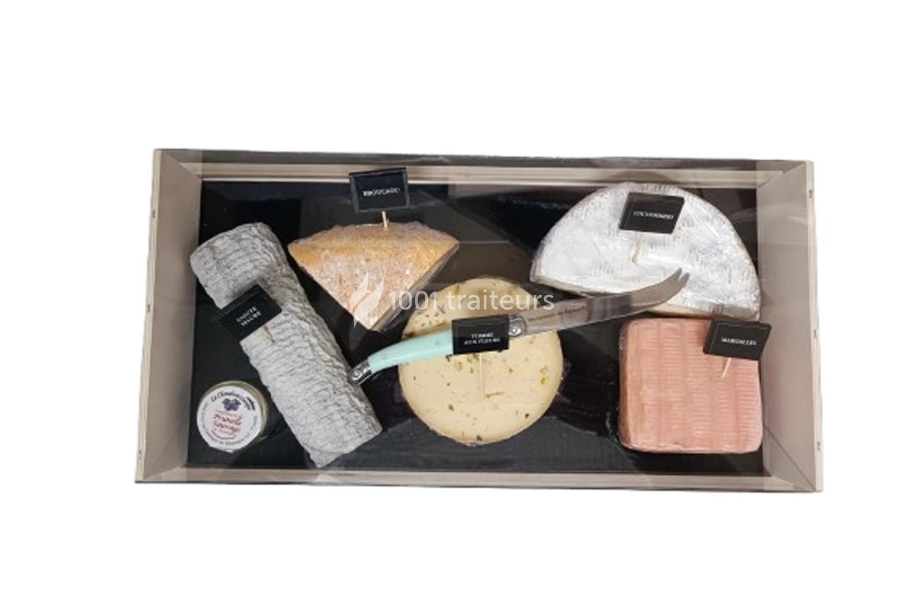 Plateau de fromages variés avec étiquettes, un couteau et une petite boîte de confiture.