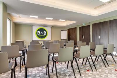 Salle de bain moderne avec douche à l'italienne, lavabo avec miroir éclairé et serviettes pliées sur une étagère.