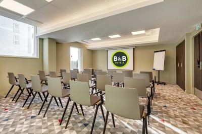 Salle de bain moderne avec douche à l'italienne, lavabo avec miroir éclairé et serviettes pliées sur une étagère.