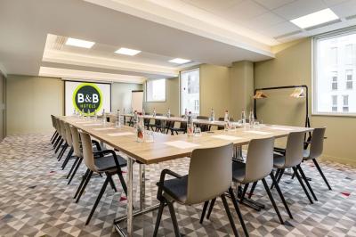 Salle de bain moderne avec douche à l'italienne, lavabo avec miroir éclairé et serviettes pliées sur une étagère.