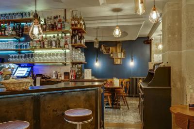 Miniature Location salle Paris 11 (Paris) - La Cascade #8 Deux choux farcis servis dans une assiette blanche avec une sauce brune, sur une table en bois.