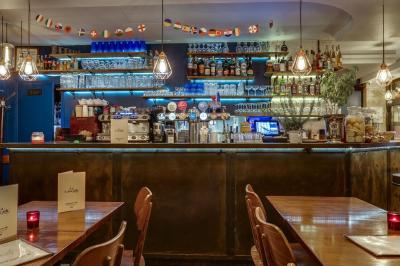 Miniature Location salle Paris 11 (Paris) - La Cascade #5 Deux choux farcis servis dans une assiette blanche avec une sauce brune, sur une table en bois.