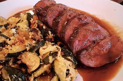 Miniature Location salle Paris 11 (Paris) - La Cascade #9 Deux choux farcis servis dans une assiette blanche avec une sauce brune, sur une table en bois.