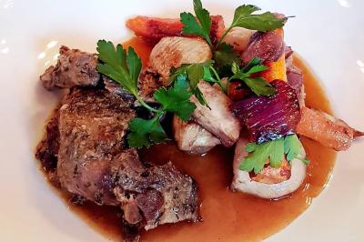 Miniature Location salle Paris 11 (Paris) - La Cascade #10 Deux choux farcis servis dans une assiette blanche avec une sauce brune, sur une table en bois.