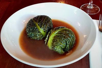 Miniature Location salle Paris 11 (Paris) - La Cascade #11 Deux choux farcis servis dans une assiette blanche avec une sauce brune, sur une table en bois.