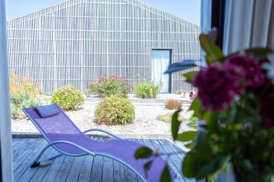 Miniature Location salle Montréverd (Vendée) - Les Villas du Parc de la Chabotterie #9 Deux chaises longues en métal avec serviettes roulées dans un espace spa, près d'un sauna en bois.
