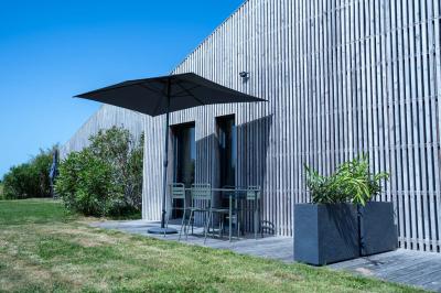 Miniature Location salle Montréverd (Vendée) - Les Villas du Parc de la Chabotterie #21 Deux chaises longues en métal avec serviettes roulées dans un espace spa, près d'un sauna en bois.