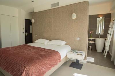 Miniature Location salle Montréverd (Vendée) - Les Villas du Parc de la Chabotterie #18 Deux chaises longues en métal avec serviettes roulées dans un espace spa, près d'un sauna en bois.