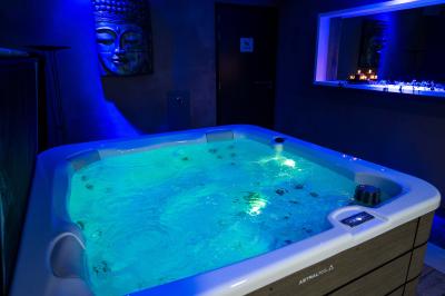 Miniature Location salle Montréverd (Vendée) - Les Villas du Parc de la Chabotterie #20 Deux chaises longues en métal avec serviettes roulées dans un espace spa, près d'un sauna en bois.