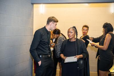 Intérieur d'un véhicule luxueux avec sièges en cuir rouge, éclairage étoilé et écran affichant une vidéo.