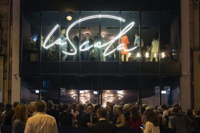 Miniature Extérieur La Scala Paris Foule rassemblée devant une façade vitrée illuminée avec le logo ’La Scala Paris’ visible à l'étage supérieur.