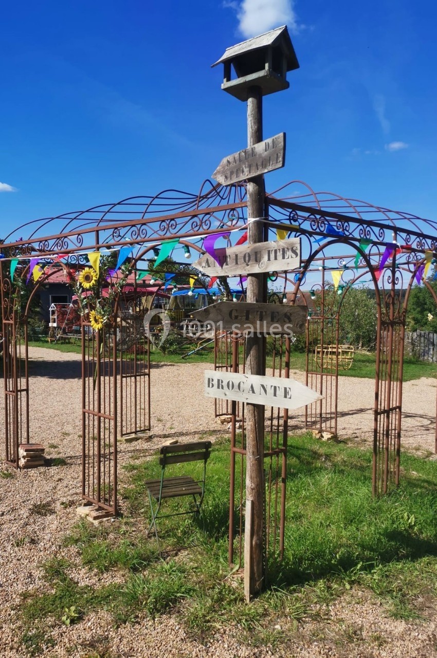 Poteau en bois avec des panneaux directionnels près d'une structure métallique décorative dans un espace extérieur…