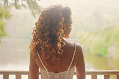 Miniature Proréal #29 Femme en robe de mariée posant près d'albums photo élégants, entourée de bijoux et d'un décor raffiné.