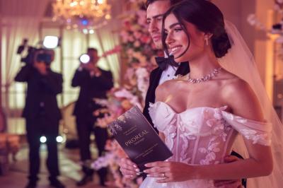 Miniature Proréal #2 Femme en robe de mariée posant près d'albums photo élégants, entourée de bijoux et d'un décor raffiné.