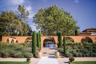 Miniature Location salle Roquebrune-sur-Argens (Var) - Château Vaudois #12 Allée rouge menant à une cérémonie en plein air, entourée de chaises blanches et de jardins verdoyants.