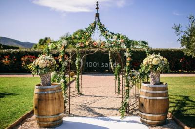 Miniature Location salle Roquebrune-sur-Argens (Var) - Château Vaudois #9 Allée rouge menant à une cérémonie en plein air, entourée de chaises blanches et de jardins verdoyants.