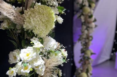 Salle moderne avec tables hautes blanches, éclairage coloré et murs vitrés, prête pour un événement.