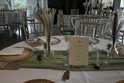 Salle moderne avec tables hautes blanches, éclairage coloré et murs vitrés, prête pour un événement.
