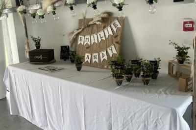 Salle moderne avec tables hautes blanches, éclairage coloré et murs vitrés, prête pour un événement.