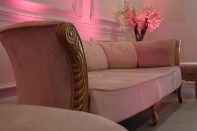 Salle moderne avec tables hautes blanches, éclairage coloré et murs vitrés, prête pour un événement.