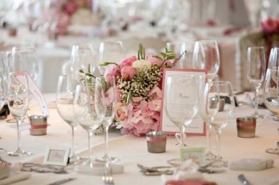 Salle moderne avec tables hautes blanches, éclairage coloré et murs vitrés, prête pour un événement.