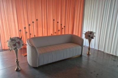 Salle moderne avec tables hautes blanches, éclairage coloré et murs vitrés, prête pour un événement.