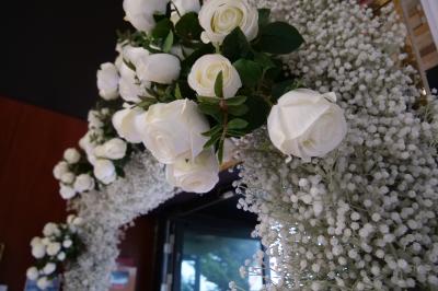 Salle moderne avec tables hautes blanches, éclairage coloré et murs vitrés, prête pour un événement.