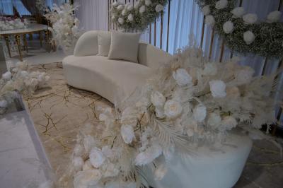 Salle moderne avec tables hautes blanches, éclairage coloré et murs vitrés, prête pour un événement.