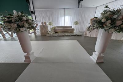 Salle moderne avec tables hautes blanches, éclairage coloré et murs vitrés, prête pour un événement.