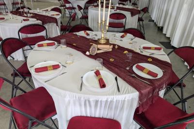 Salle moderne avec tables hautes blanches, éclairage coloré et murs vitrés, prête pour un événement.