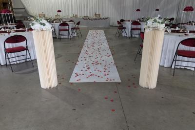 Salle moderne avec tables hautes blanches, éclairage coloré et murs vitrés, prête pour un événement.