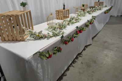 Salle moderne avec tables hautes blanches, éclairage coloré et murs vitrés, prête pour un événement.