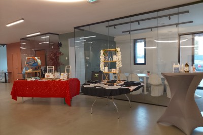 Un Père Noël décoratif près d'un sapin orné de boules argentées et de guirlandes rouges, dans un décor festif.