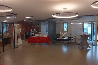 Un Père Noël décoratif près d'un sapin orné de boules argentées et de guirlandes rouges, dans un décor festif.