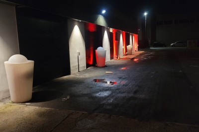 Un Père Noël décoratif près d'un sapin orné de boules argentées et de guirlandes rouges, dans un décor festif.