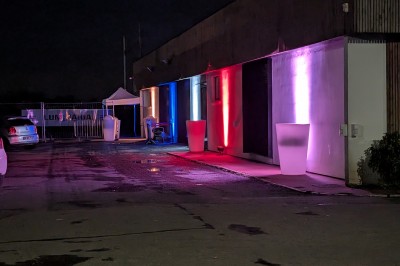 Un Père Noël décoratif près d'un sapin orné de boules argentées et de guirlandes rouges, dans un décor festif.