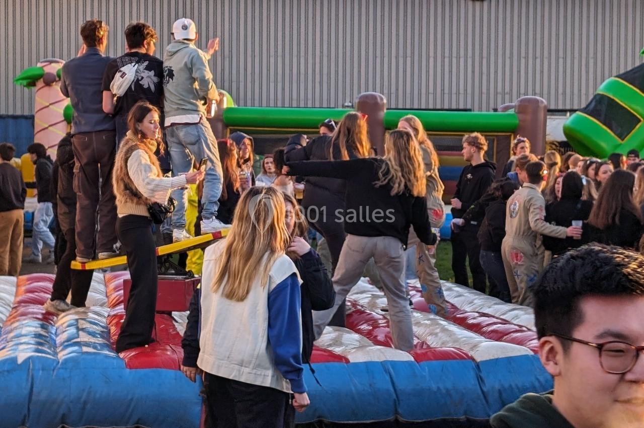 Des personnes participent à une activité sur une structure gonflable lors d'un événement en plein air.