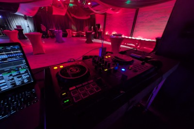 Des enfants colorient des dessins autour d'une table ronde, entourés d'adultes dans un espace intérieur animé.