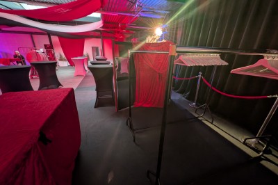 Des enfants colorient des dessins autour d'une table ronde, entourés d'adultes dans un espace intérieur animé.