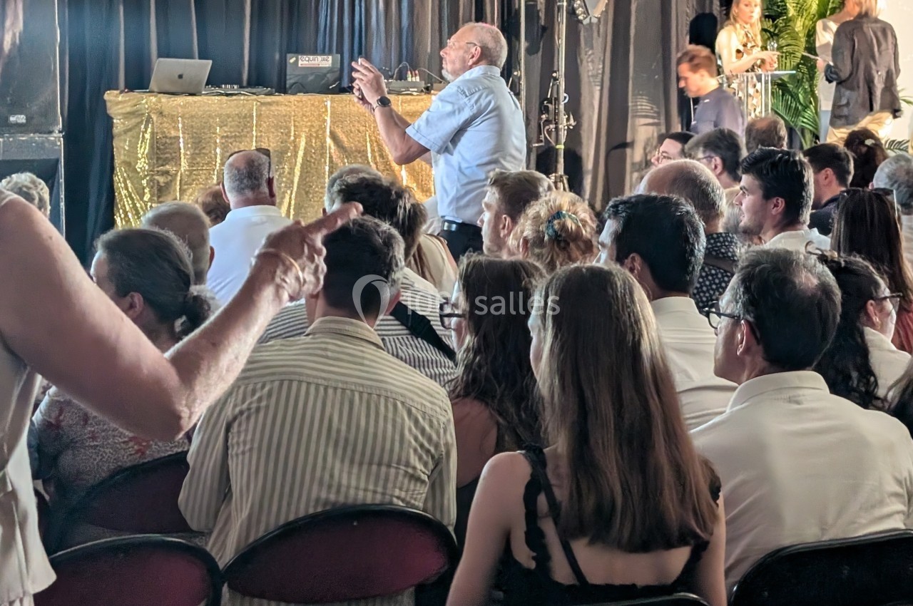 Un groupe de personnes assises dans une salle, certaines debout, lors d'un événement ou d'une présentation.